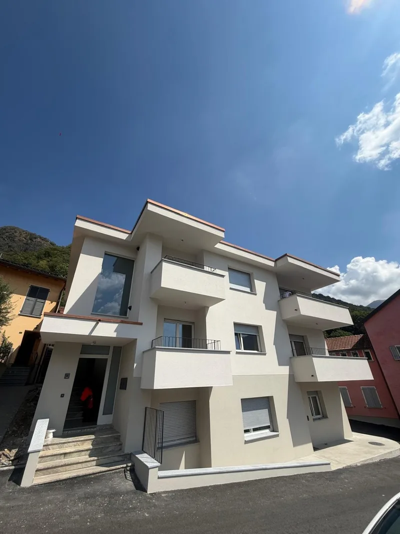 Palazzina con facciata chiara, balconi e cielo azzurro