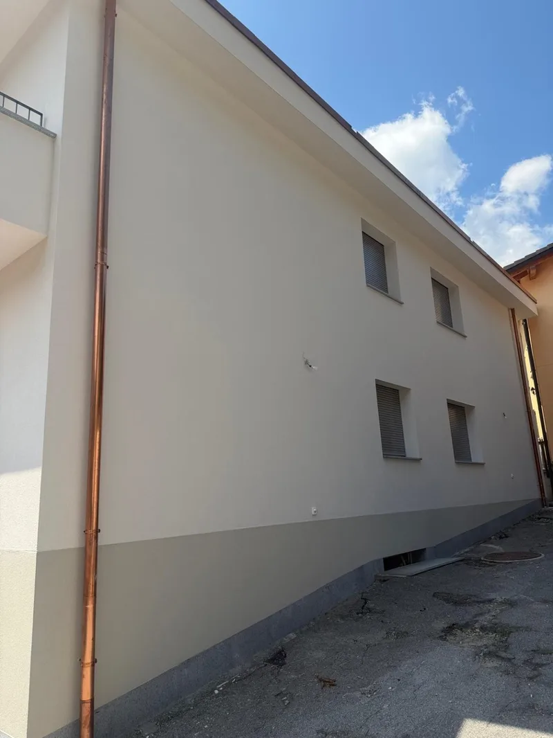 Parete esterna chiara con zoccolatura grigia